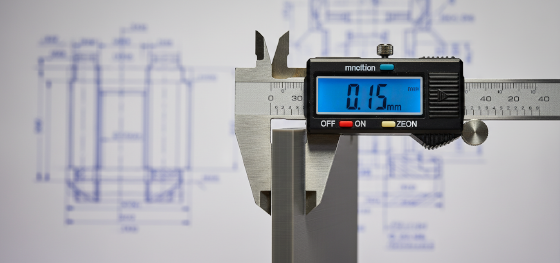 Digital caliper measuring the wall thickness of an SLA resin prototype displaying a tolerance deviation
