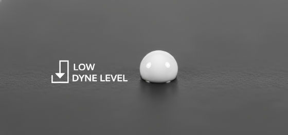 Microscopic view of water-based paint failing to wet a low-surface-energy plastic substrate due to poor dyne levels