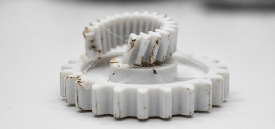 Failed plastic gear exhibiting severe thermal warpage representing the thermodynamic failure of extrusion printing