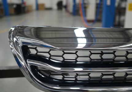 Flawless chrome plated ABS automotive grille reflecting bright factory lighting without any blistering.png